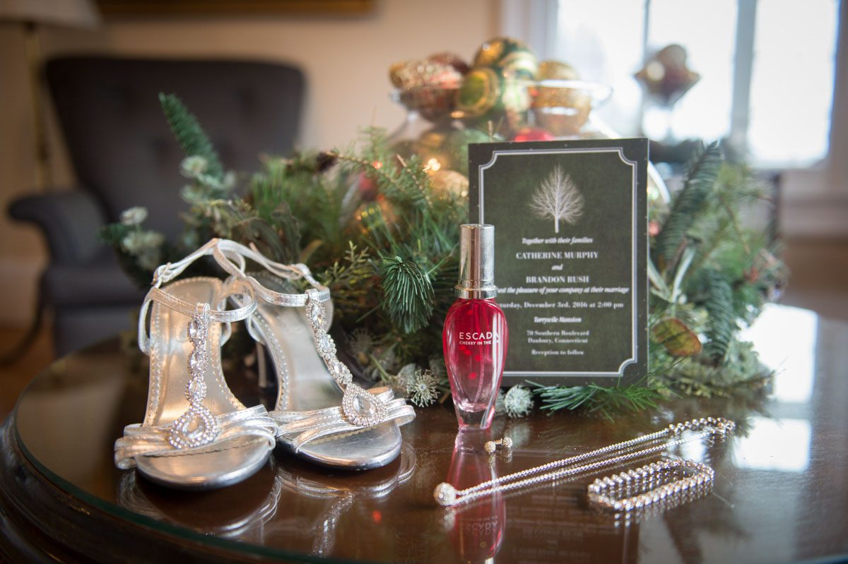 shoes, perfume, invitation and jewelry on table with decorations